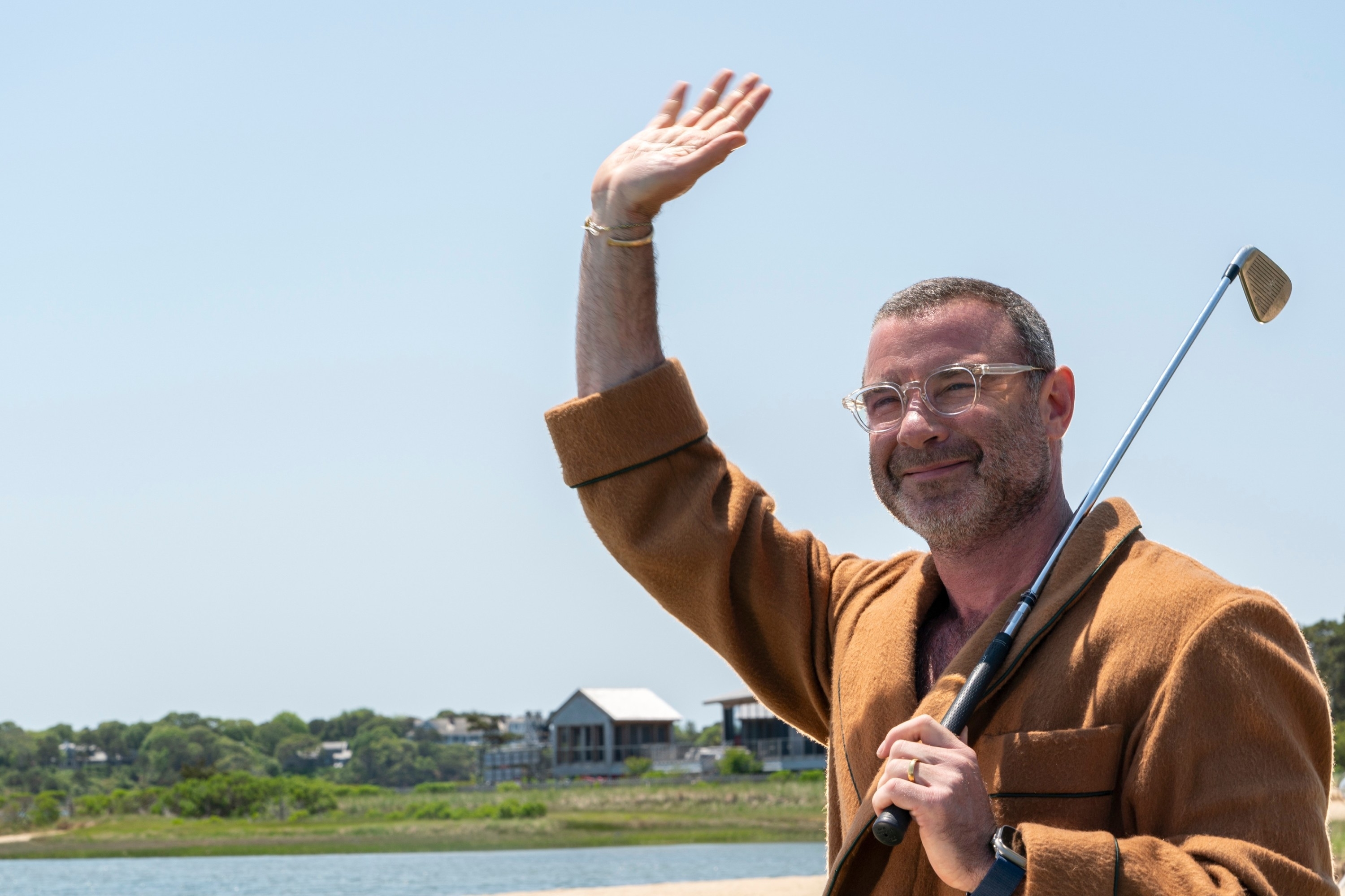 Liev Schreiber holding a golf club in "The Perfect Couple"