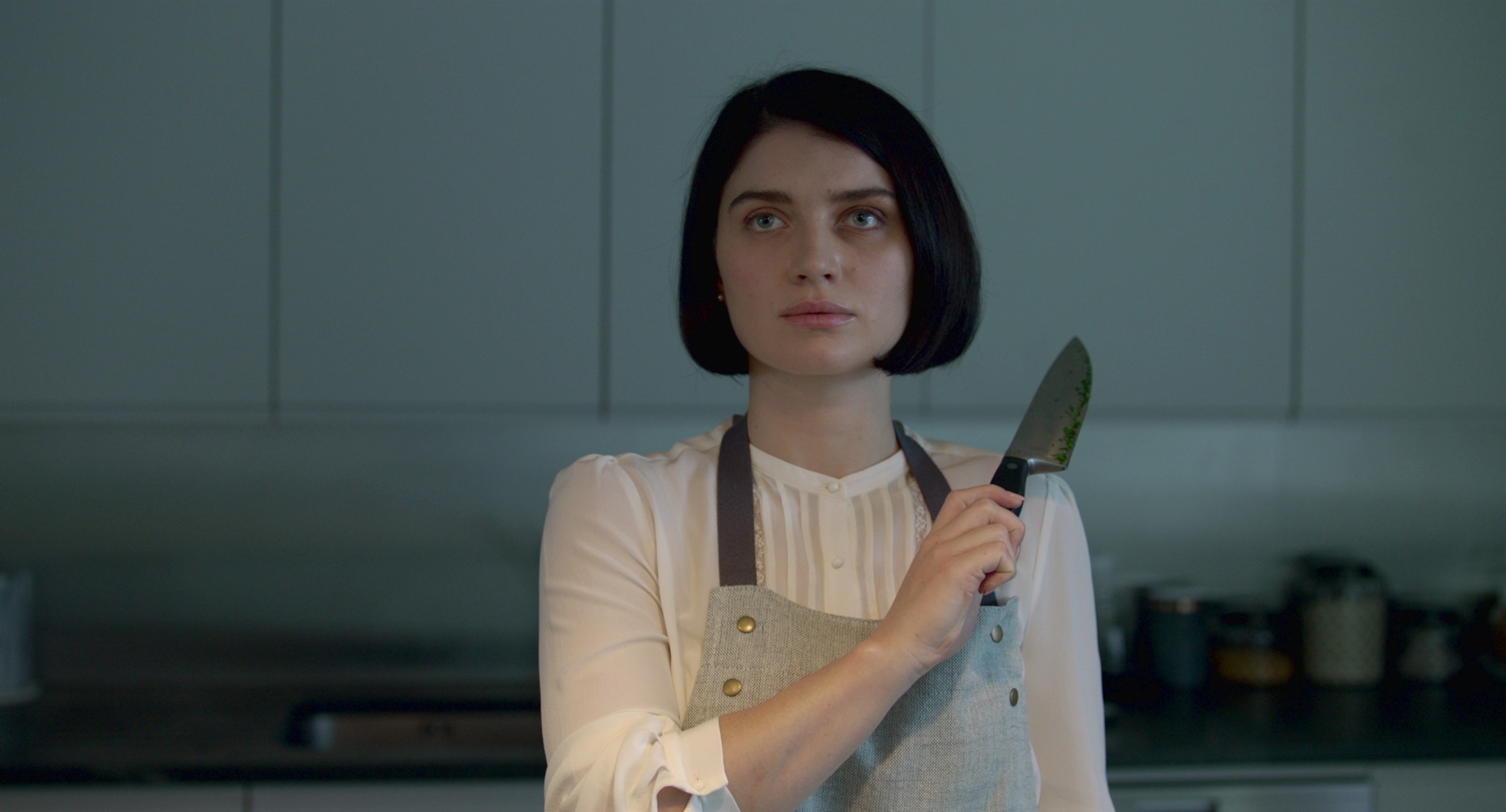 Eve Hewson holding a knife in "Behind Her Eyes"