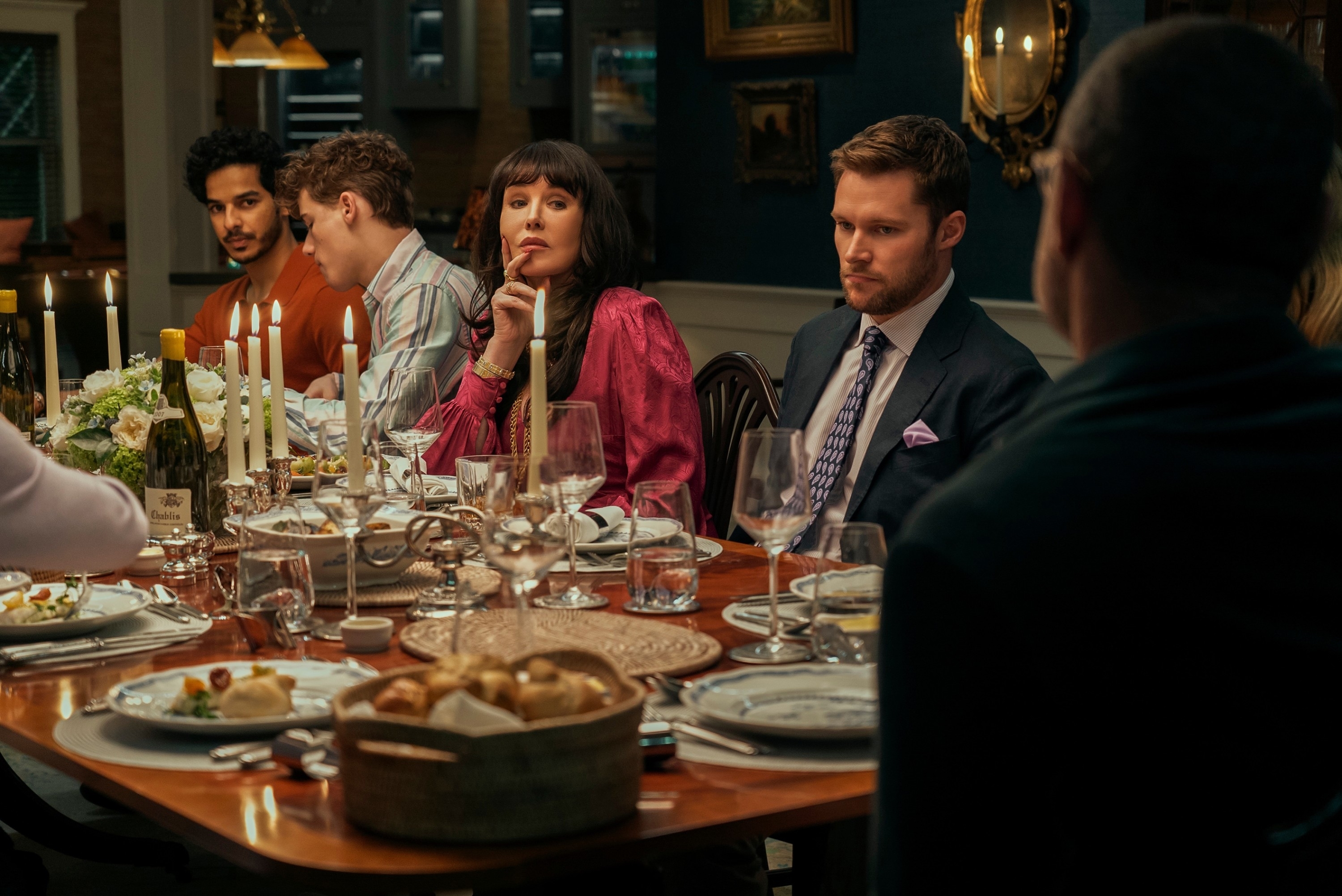 Ishaan Khattar, Sam Nivola, Isabelle Adjani, Jack Reynor, and Liev Schreiber at a dinner scene in "The Perfect Couple"