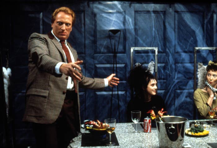 Jeffrey Jones standing up at a table in "Beetlejuice"