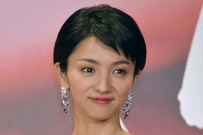 Zhou Xunさんがレッドカーペットでスパンコールが付いたドレスを着てポーズを取っています。