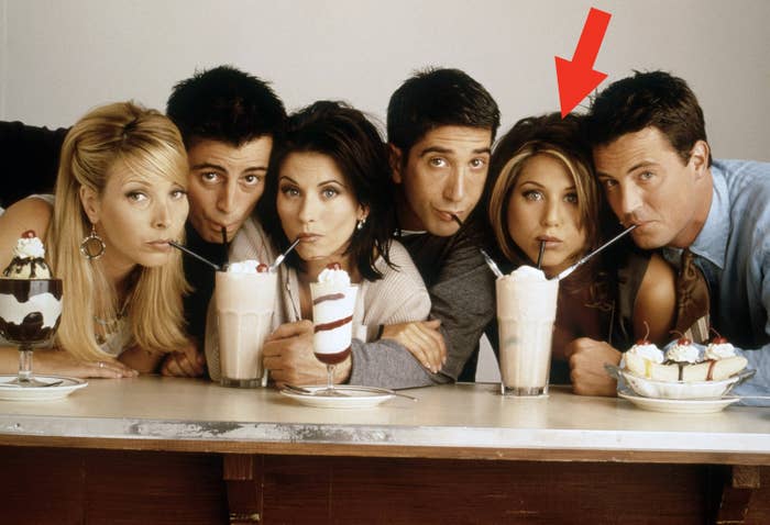 Lisa Kudrow, Matt LeBlanc, Courteney Cox, David Schwimmer, Jennifer Aniston, and Matthew Perry drinking milkshakes behind a counter