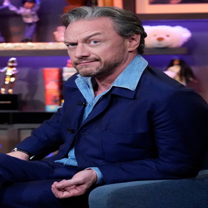 James McAvoy seated during an interview on a talk show, wearing a navy suit with a light blue shirt underneath