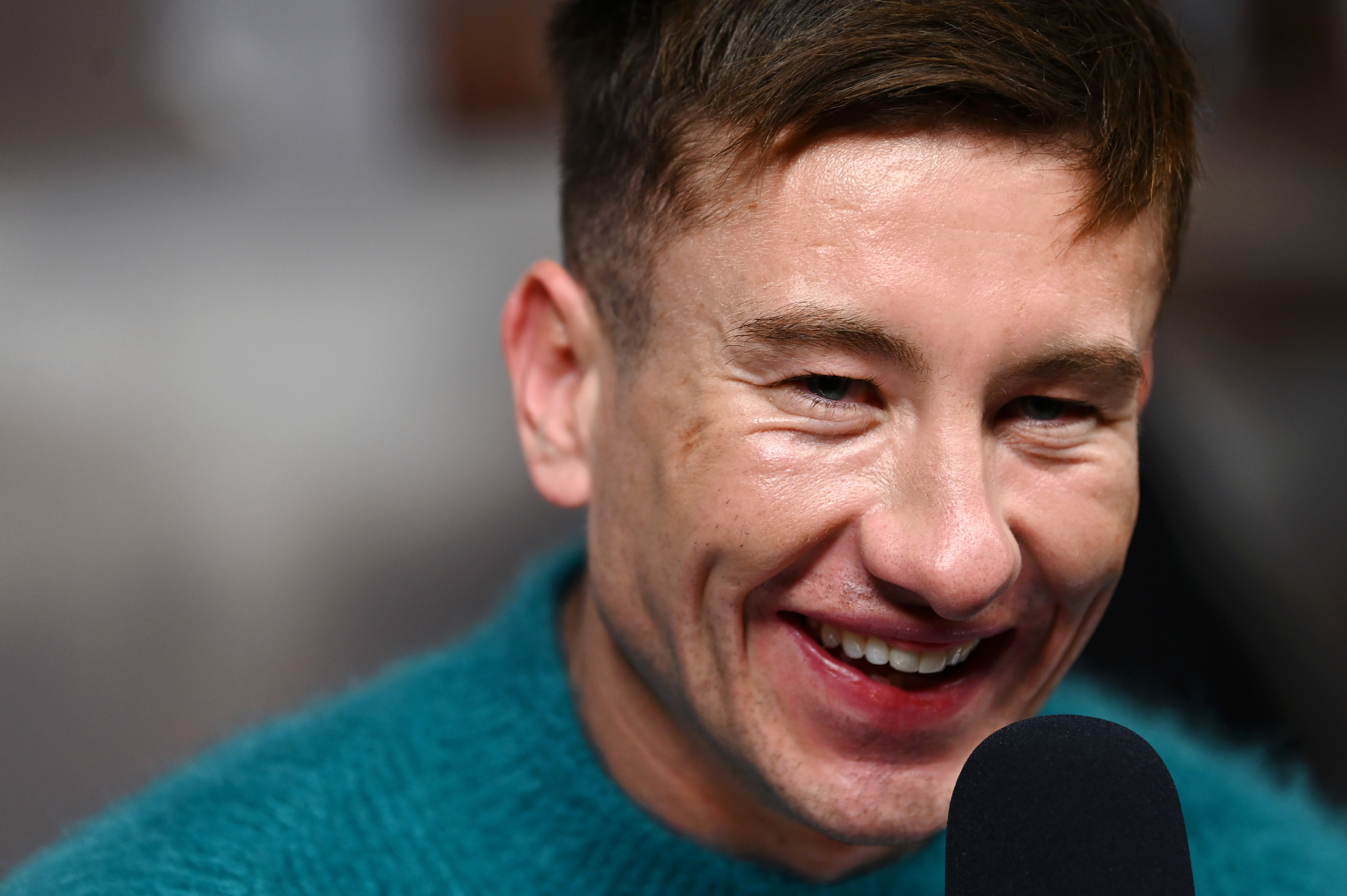 Barry Keoghan smiles while talking into a microphone