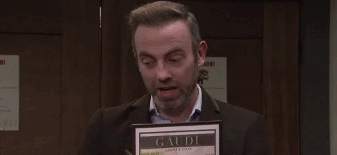 A man holding a menu and speaking animatedly.