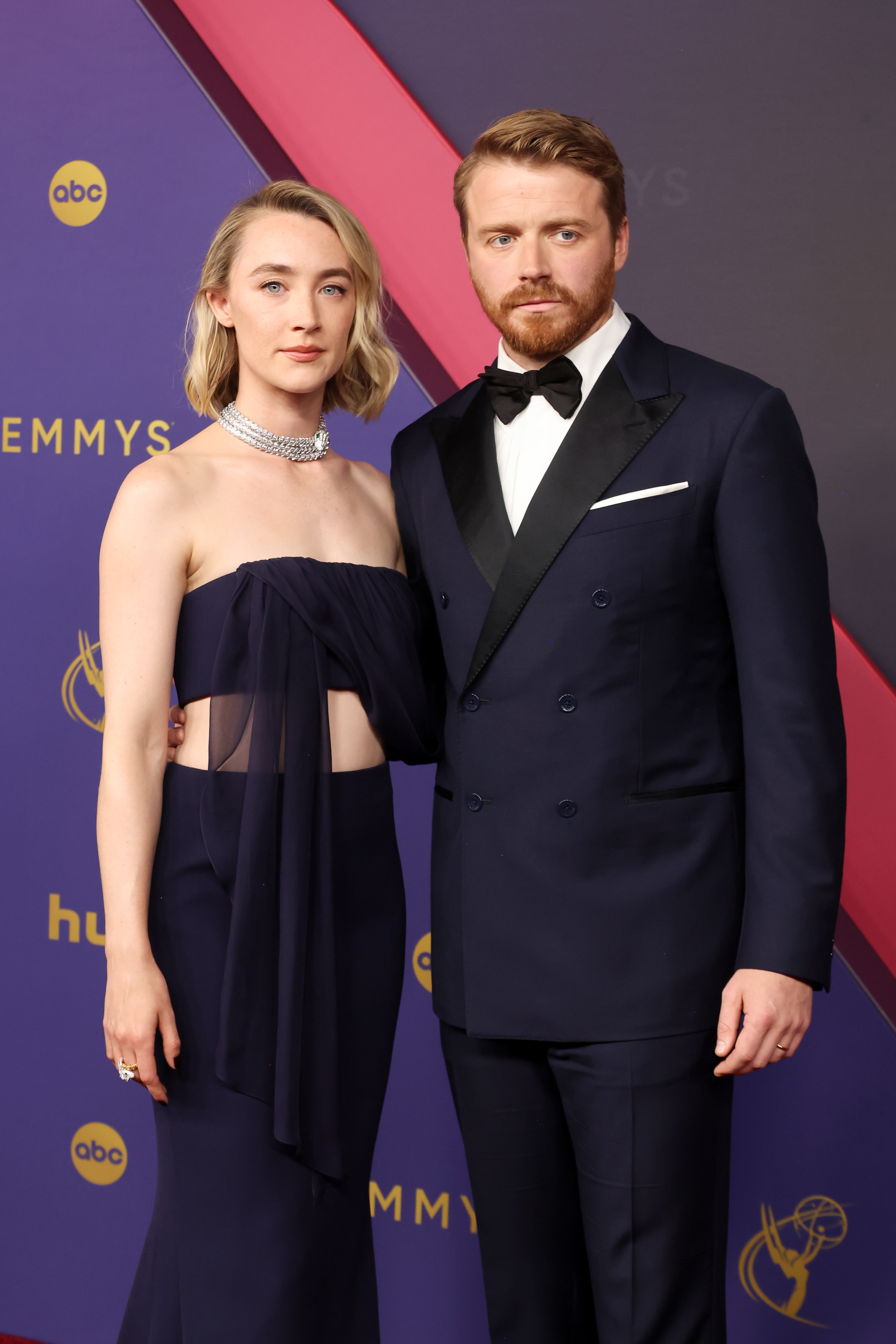 Saoirse Ronan in an elegant strapless dress with sheer elements and Jack Lowden in a classic tuxedo at the Emmy Awards red carpet