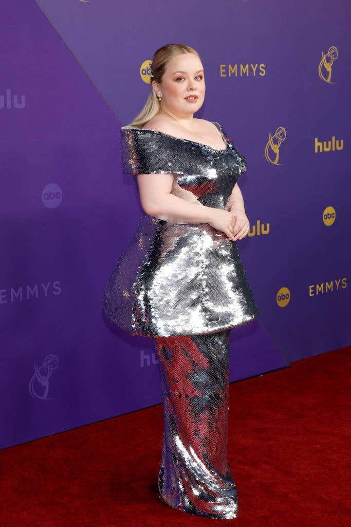 Nicole Coughlan en la alfombra roja de los Emmys con un vestido brillante de lentejuelas plateadas y corte asimétrico
