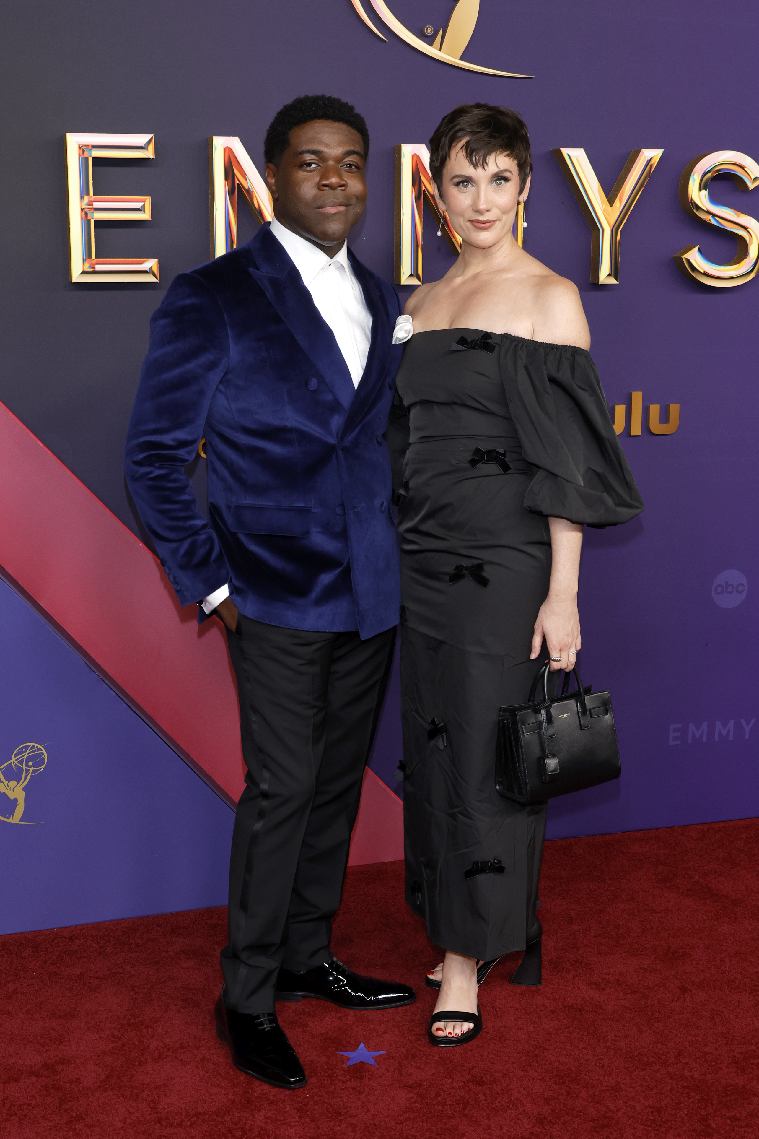 Sam Richardson in a blue velvet suit and Nicole Boyd in a black off-the-shoulder dress on the red carpet at the Emmys