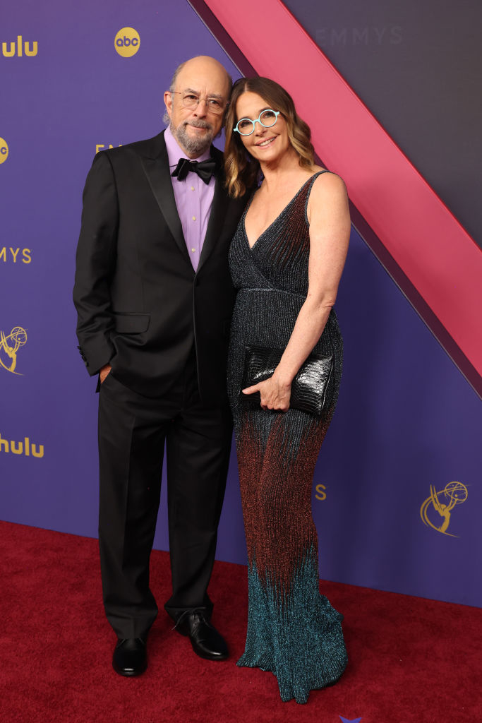 Richard Schiff and Sheila Kelley stand together on the red carpet, both dressed elegantly for the event. `