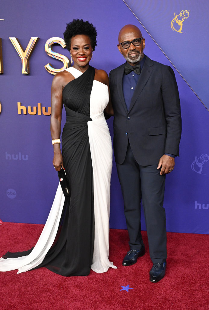 Viola Davis in a black and white gown and Julius Tennon in a dark suit pose together on the red carpet at an event