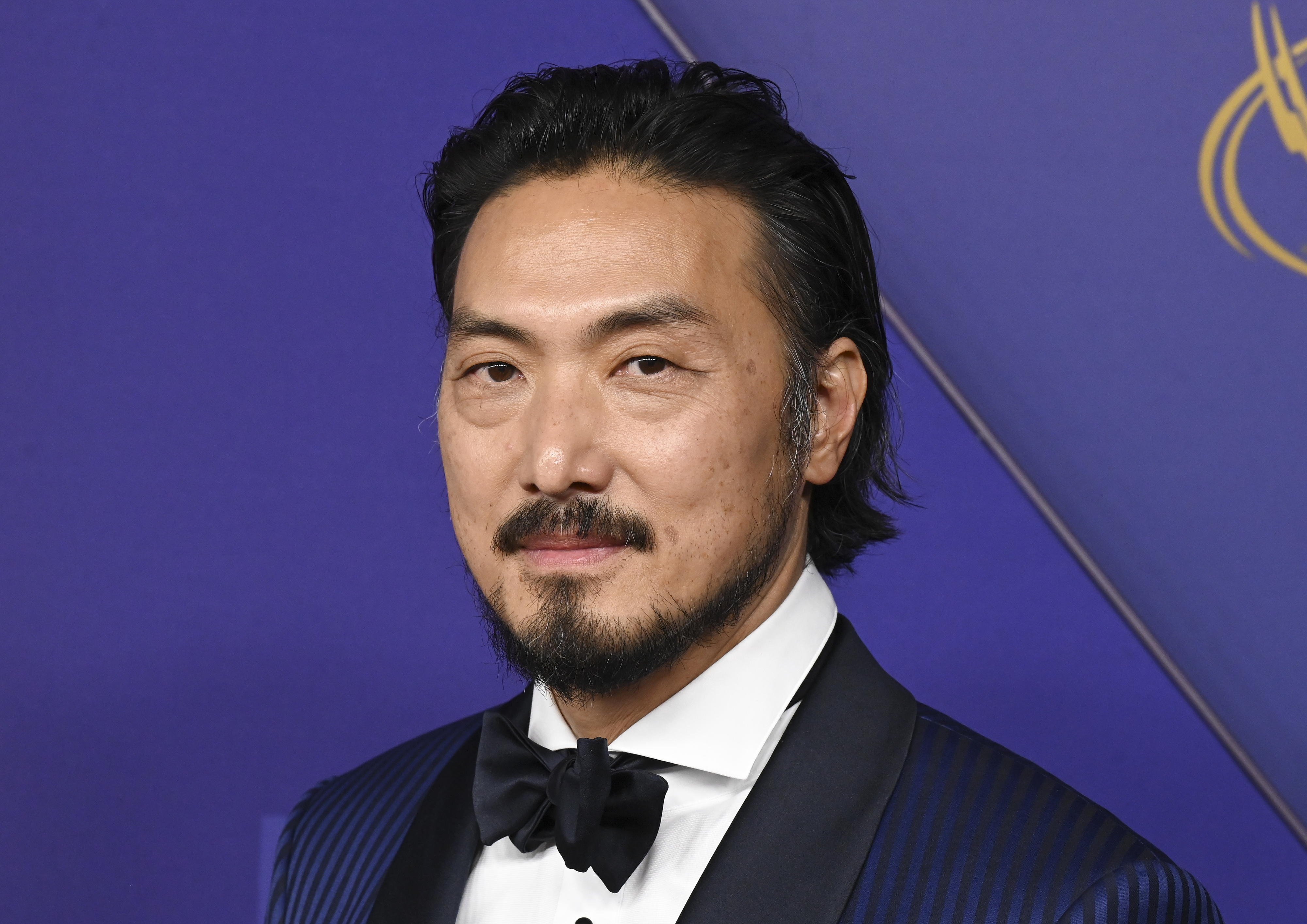 Takehiro Hira in formal attire with a bow tie, posing against a backdrop at a formal event