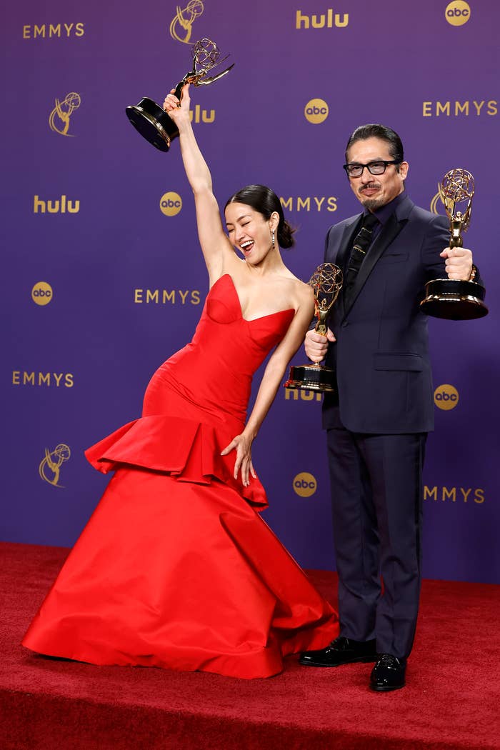 Anna Sawai and Hiroyuki Sanada holding Emmy awards, standing on the red carpet