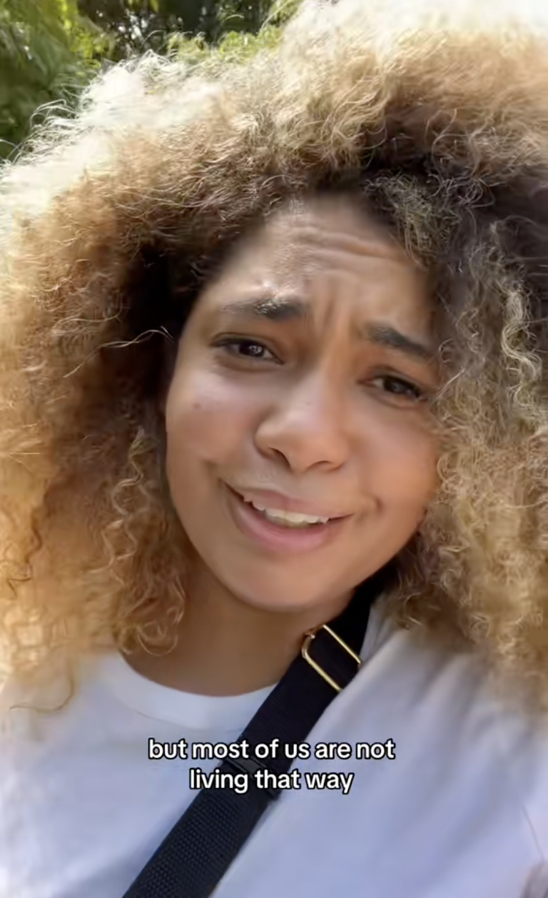 Lauren with curly hair speaks in a video. Text on image: "but most of us are not living that way"