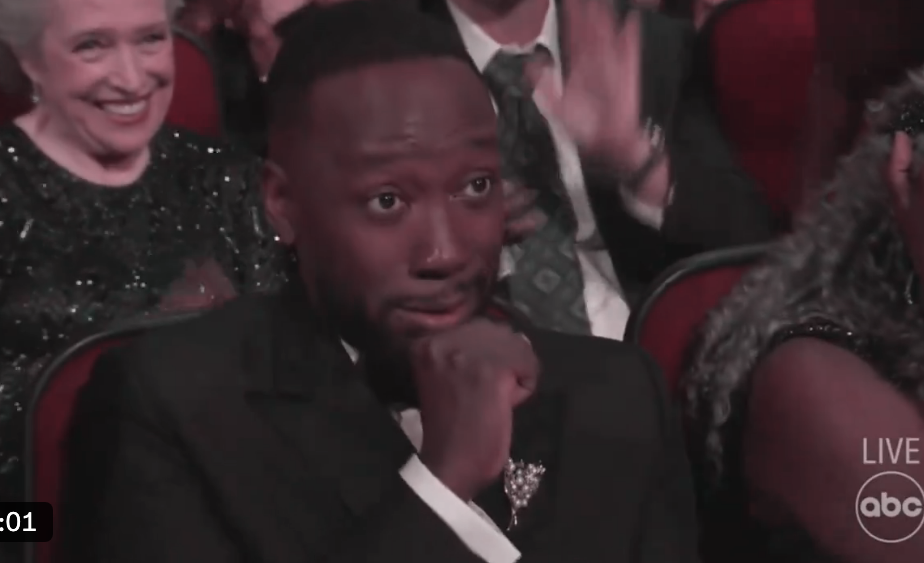 Actor Lamorne Morris in a tuxedo, with gripping expression, hands on chin