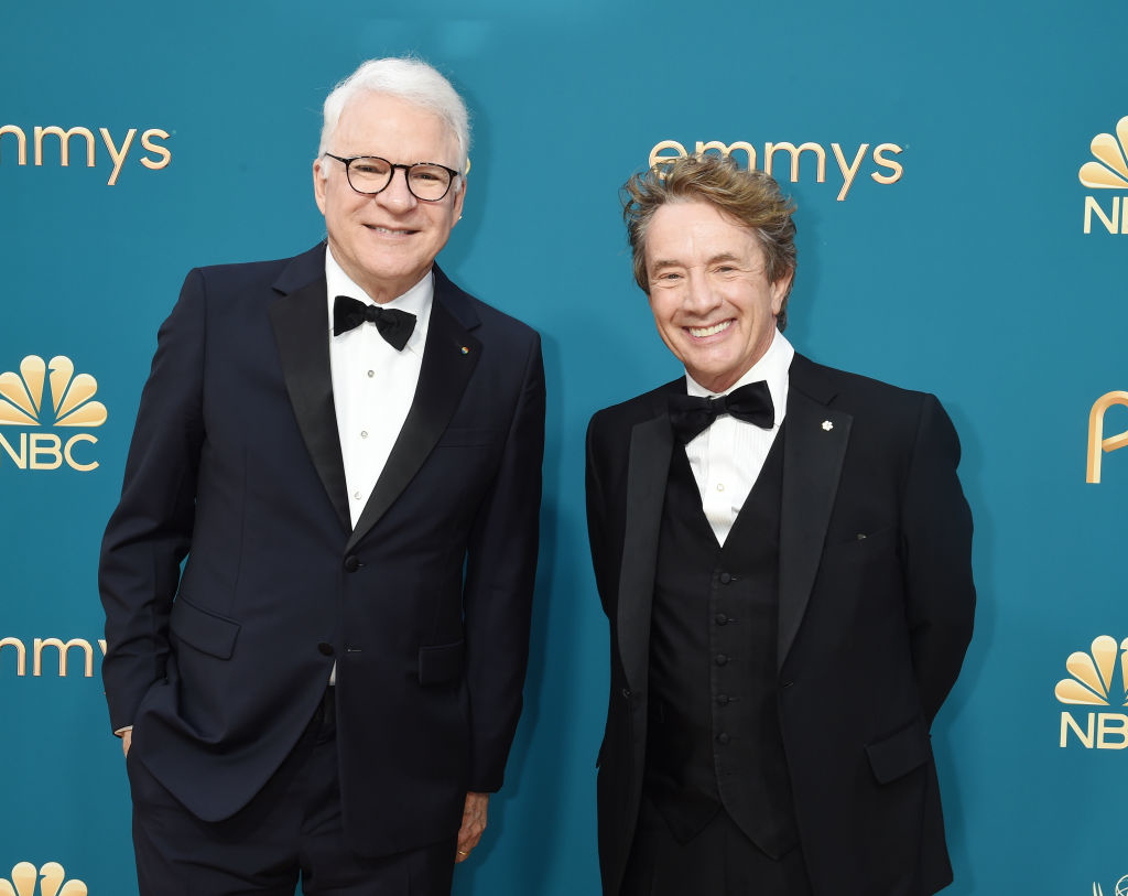 Steve Martin and Martin Short smiling on the red carpet at the Emmys, wearing classic black tuxedos