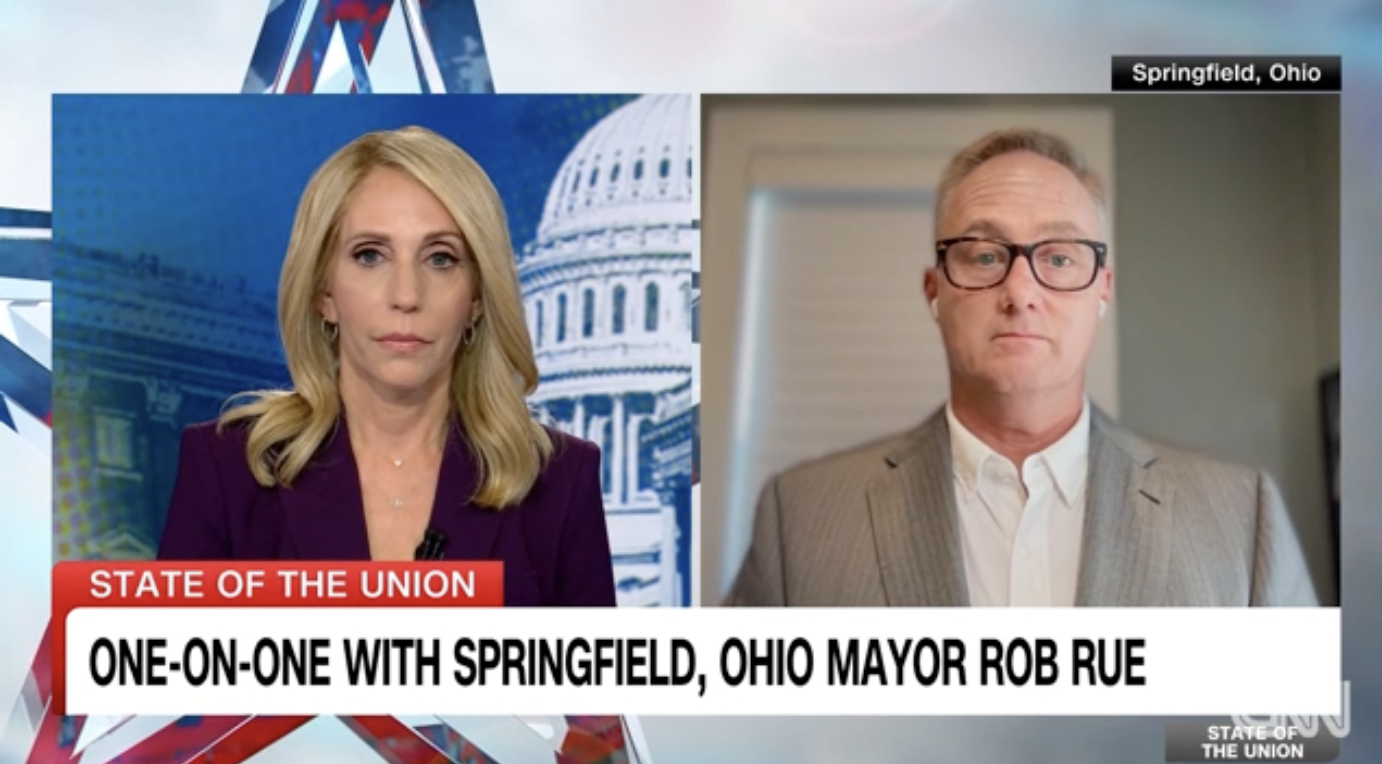 Dana Bash interviews Springfield, Ohio Mayor Rob Rue, who is wearing a suit and glasses, on CNN's State of the Union