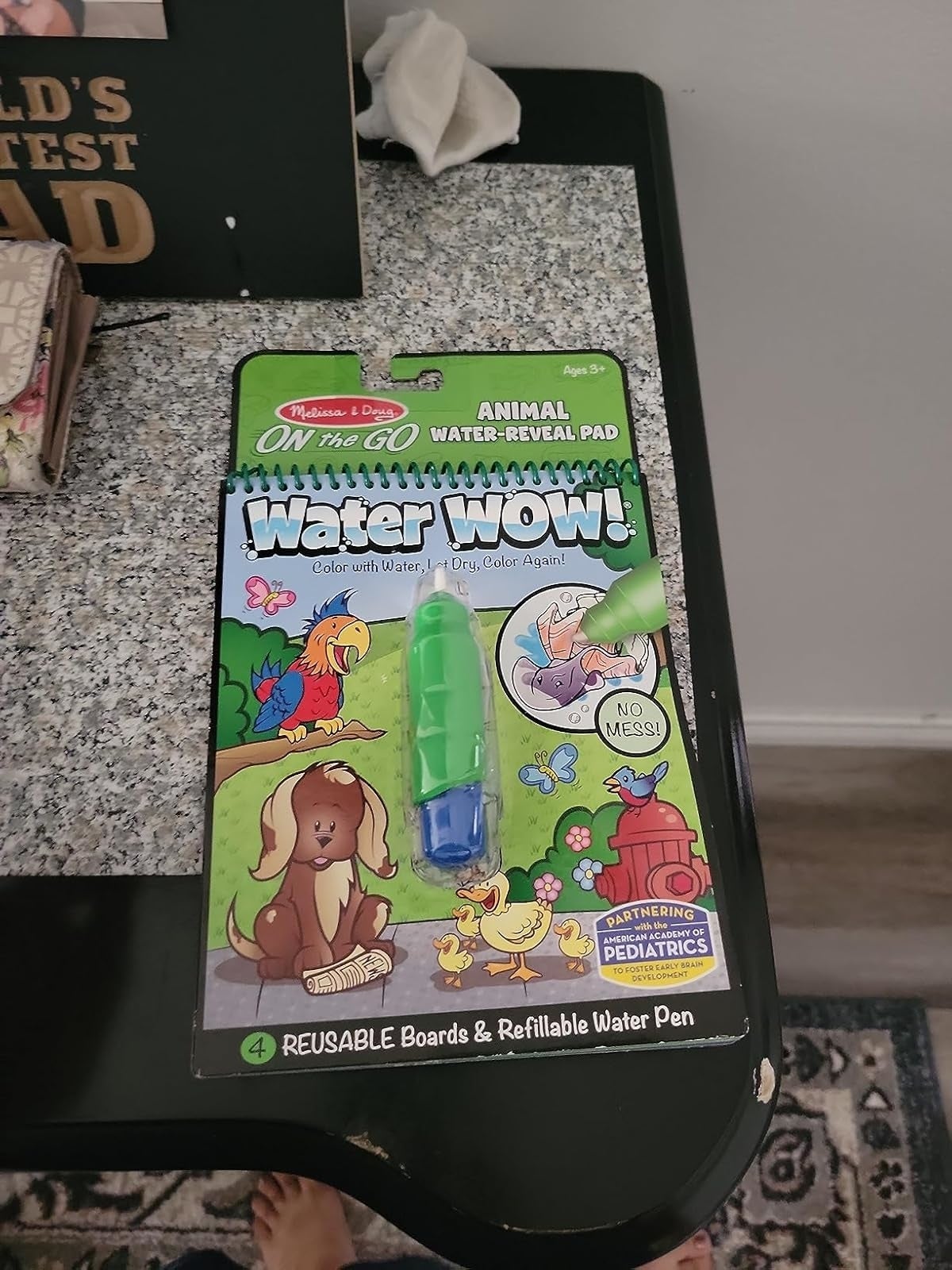 Melissa & Doug On the Go Water Wow! Animal water-reveal pad with a greenish  refillable h2o  pen shown connected  a countertop