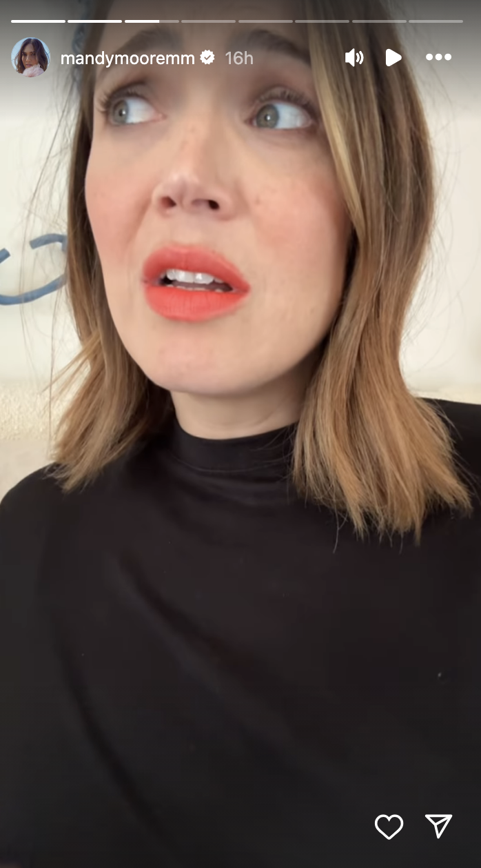 Mandy Moore wearing a black top with a concerned expression on her face