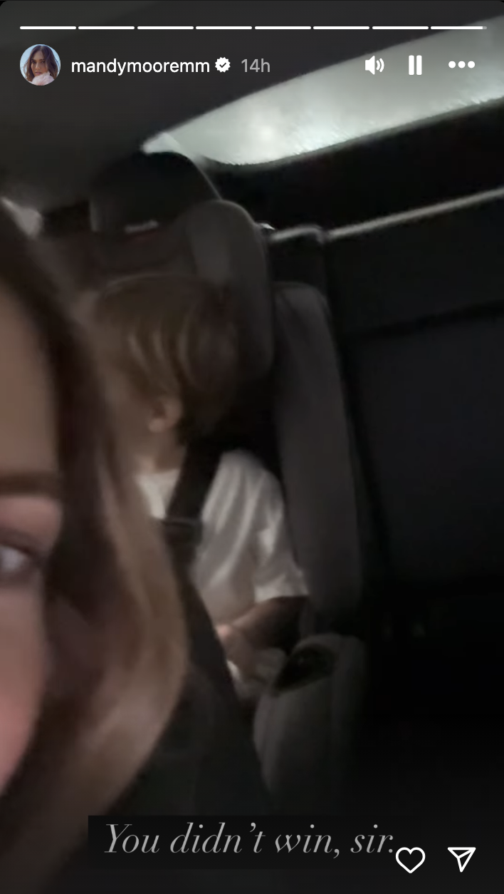Mandy Moore takes a selfie in a car with her child in the backseat; Instagram story text reads, "You didn't win, sir."