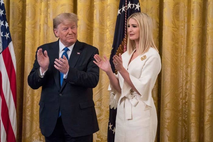 Donald Trump and Ivanka Trump stand and clap in a formal setting, with Donald in a suit and Ivanka in a white dress