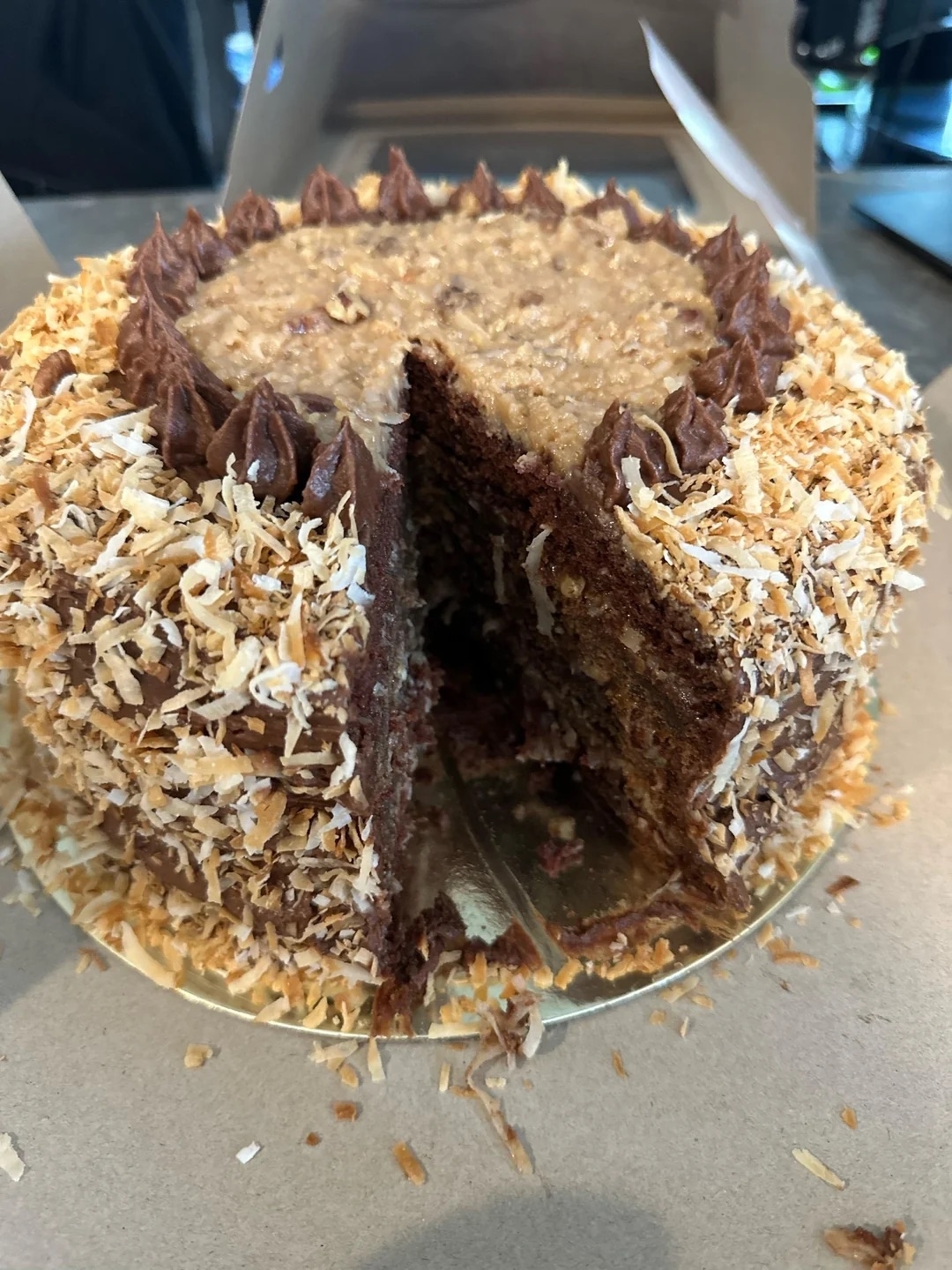 Chocolate cake with toasted coconut flakes and a slice cut out