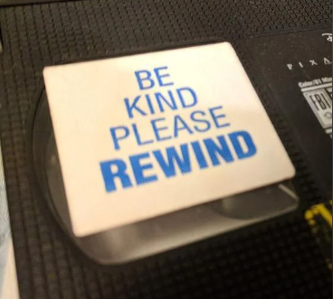 Close-up image of a VHS tape with a label that reads "Be Kind Please Rewind."