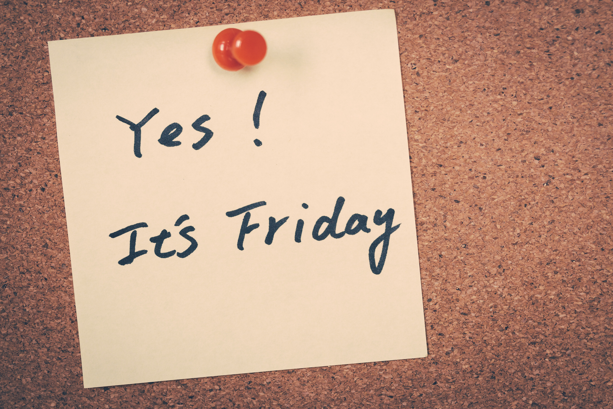 Sticky note pinned to corkboard with handwritten text: "Yes! It's Friday."