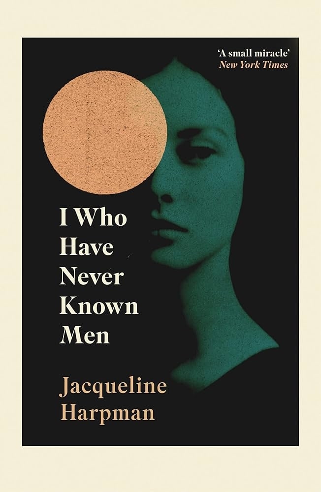 Book cover of "I Who Have Never Known Men" by Jacqueline Harpman features a woman's face partially obscured by a large circle. Text includes a New York Times quote: "A small miracle."