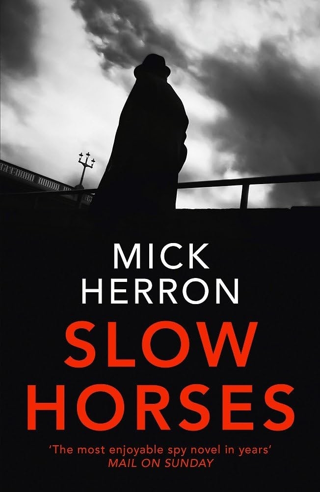 Cover of "Slow Horses" by Mick Herron, featuring a silhouette of a person in a hat and coat, with the text "The most enjoyable spy novel in years" - Mail on Sunday