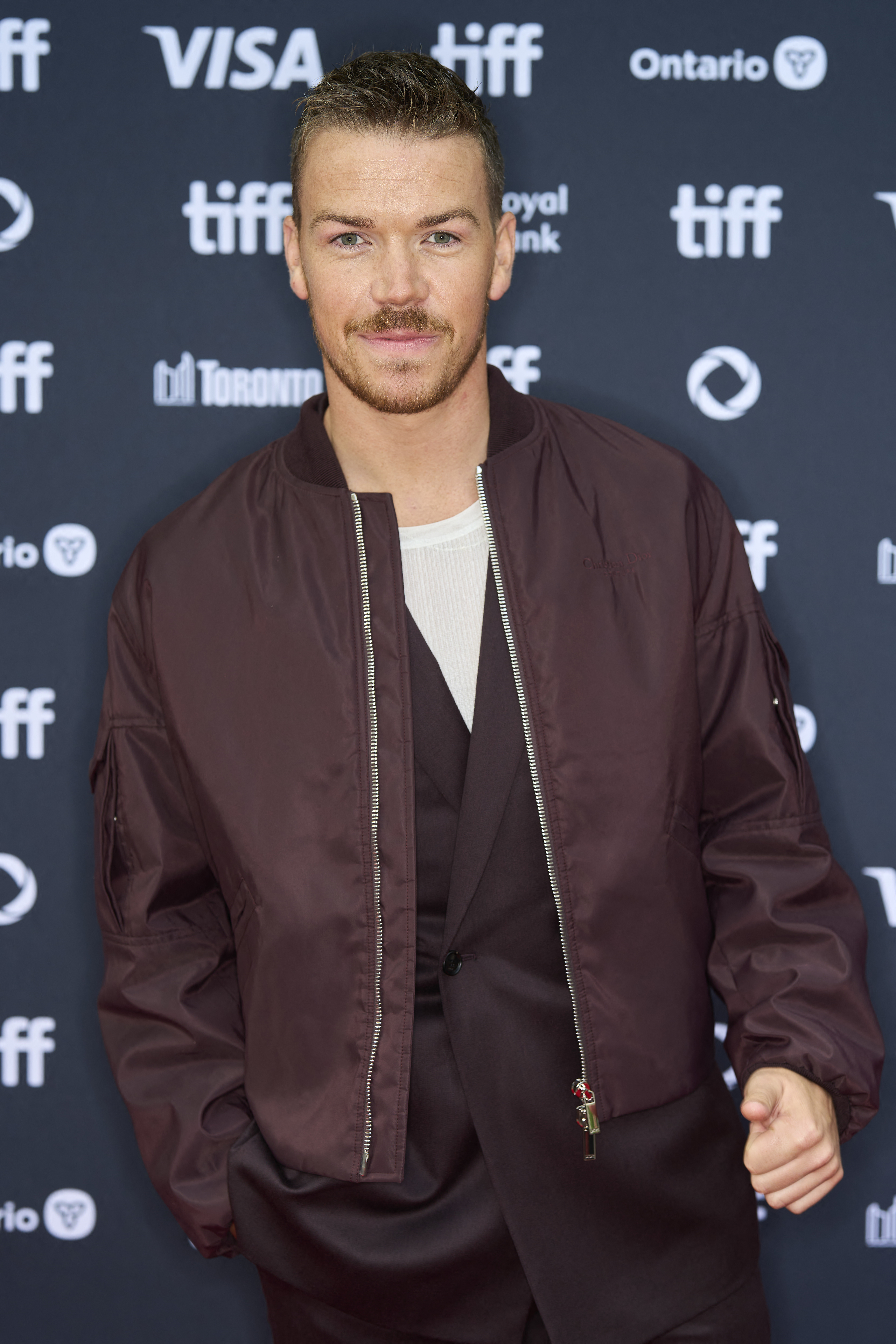 Will Poulter on the red carpet at the Toronto International Film Festival, wearing a casual jacket over a suit