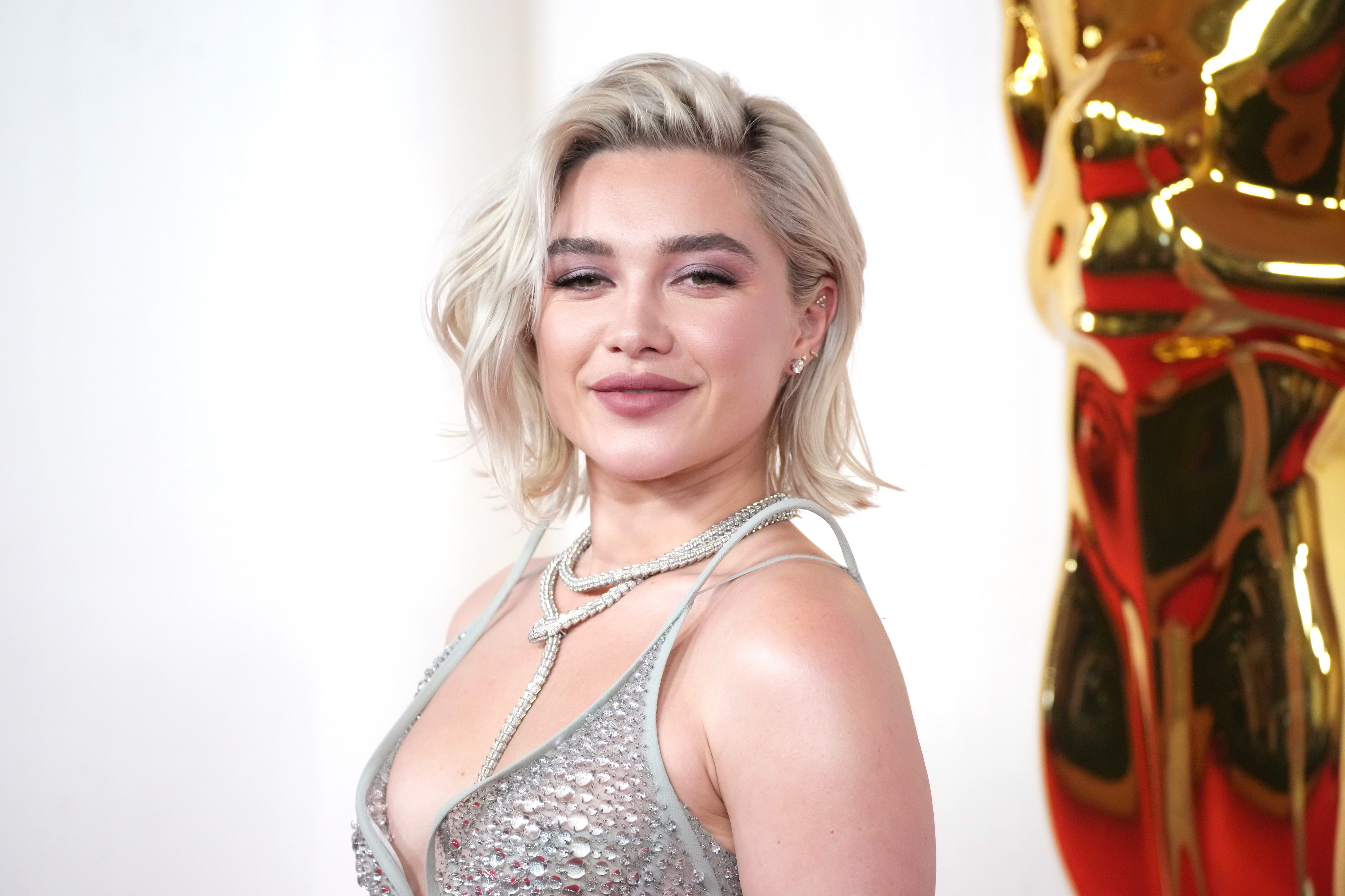 Florence Pugh in a sequined dress with layered necklaces on the red carpet