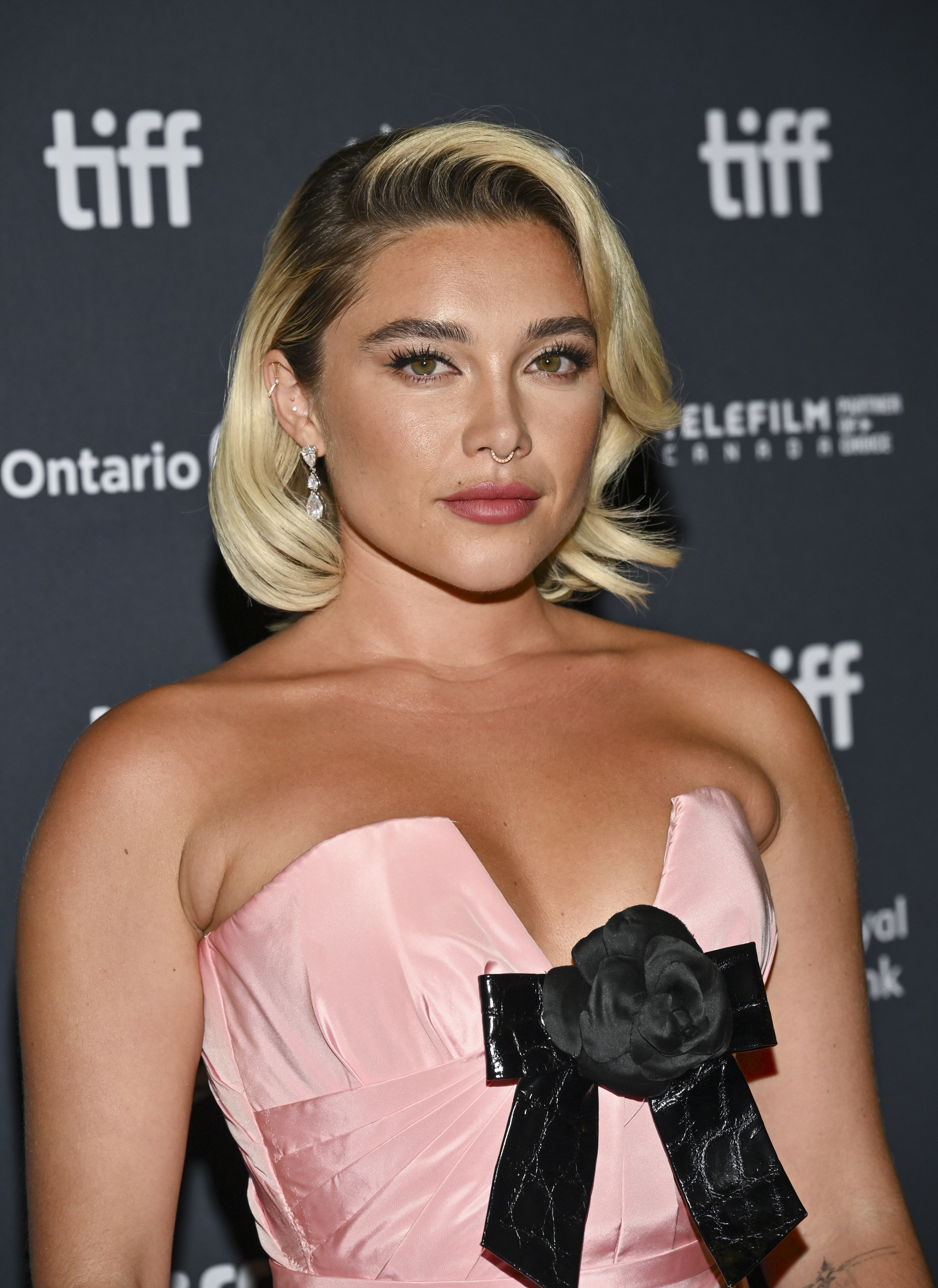 Florence Pugh at TIFF wearing a strapless dress with a floral accent