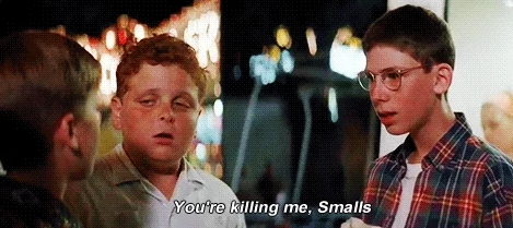 Scene from "The Sandlot" with three boys talking. One boy says, "You're killing me, Smalls," a famous line from the movie