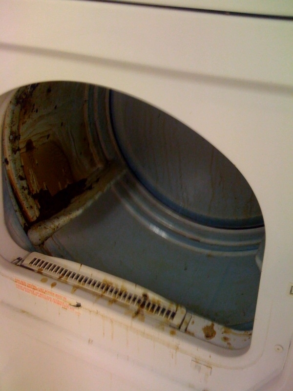 Open, dirty dryer drum with grime and stains. No people are in the image