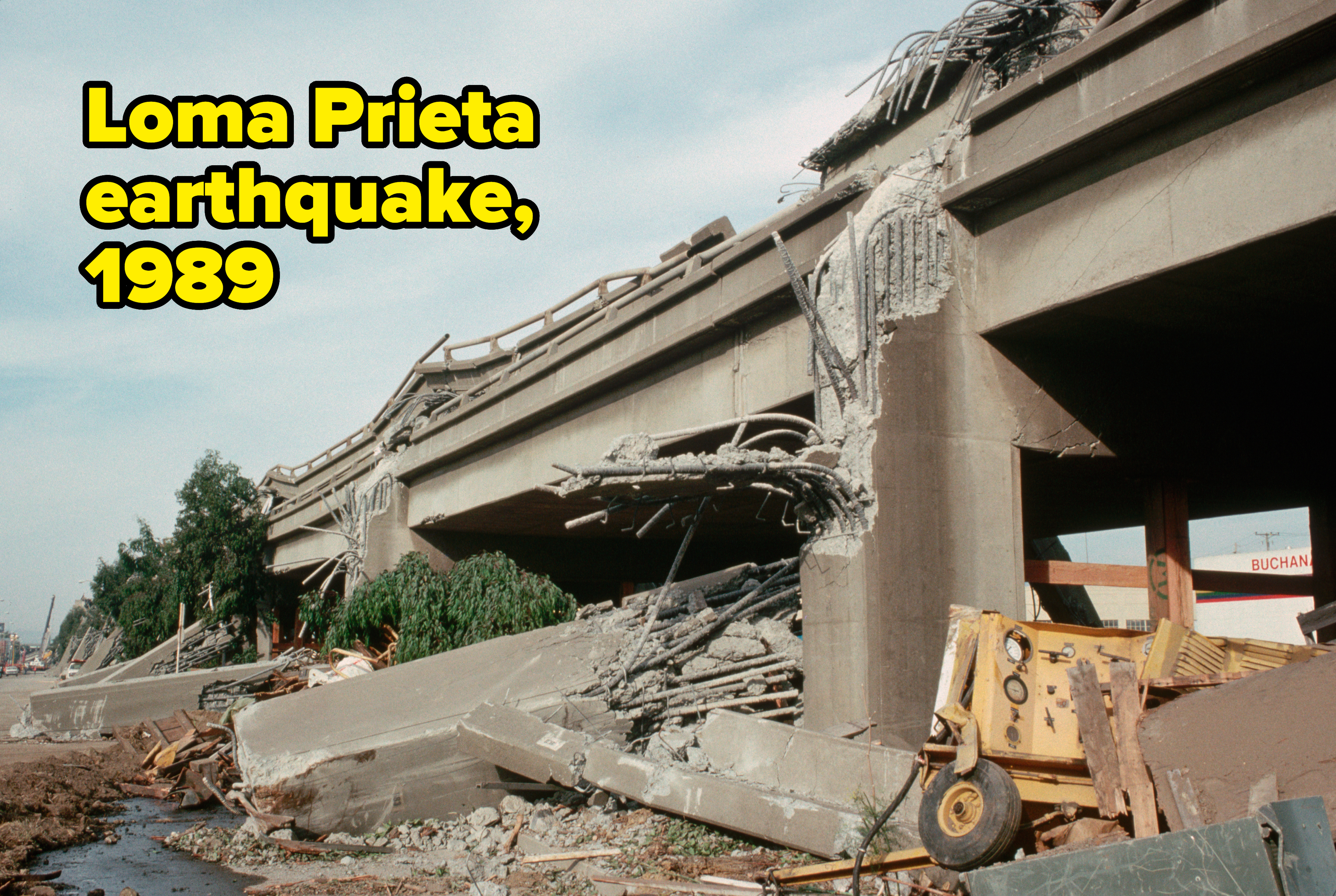 Collapsed highway structure with heavy damage caused by the 1989 Loma Prieta earthquake. Debris and a construction vehicle are present