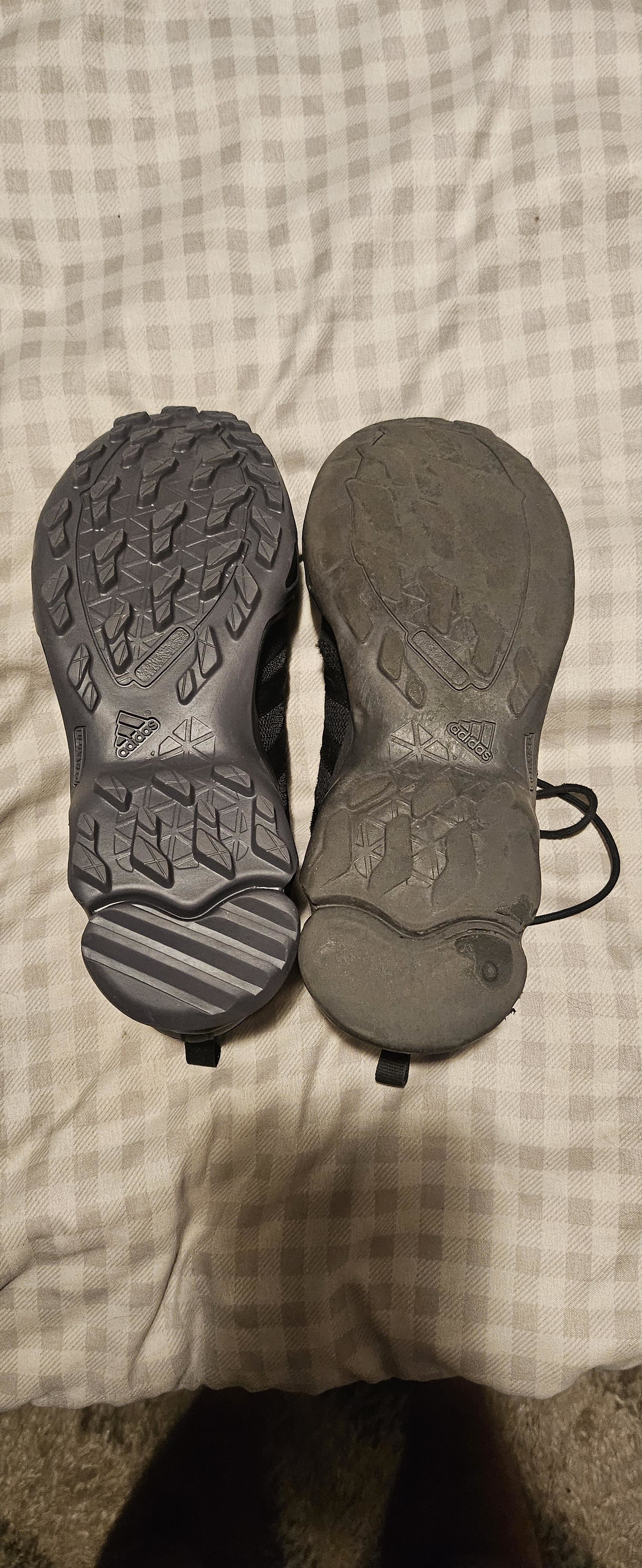 New and worn pair of sneaker soles placed side by side, highlighting the contrast in the condition of the treads. No people are present in the image
