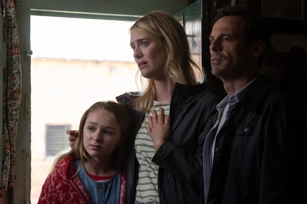 Maddie Nichols, Elizabeth Marvel, and Walton Goggins stand closely together, looking concerned, in a scene from a film or TV show