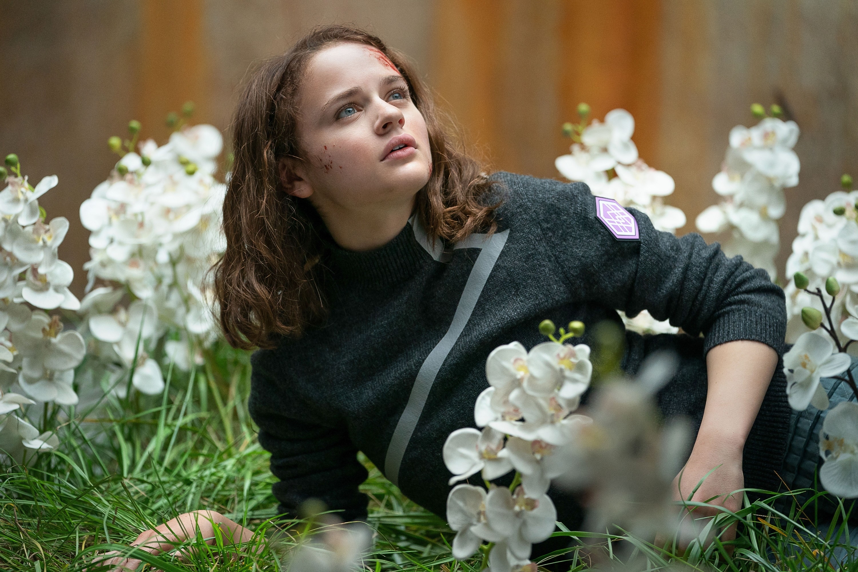 Joey King sitting in a field of flowers in "Uglies"