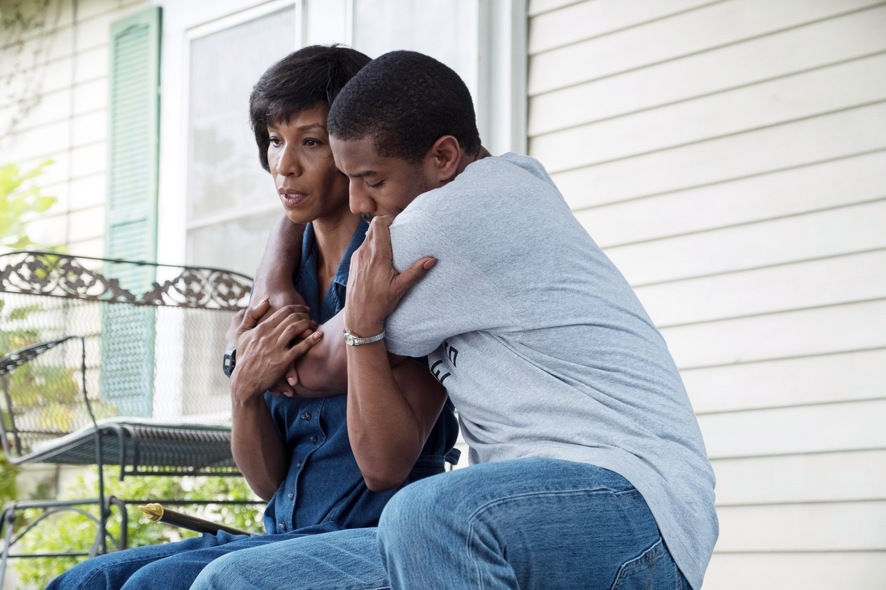 Charmin Lee, Michael B. Jordan hugging on a porch in "Just Mercy"