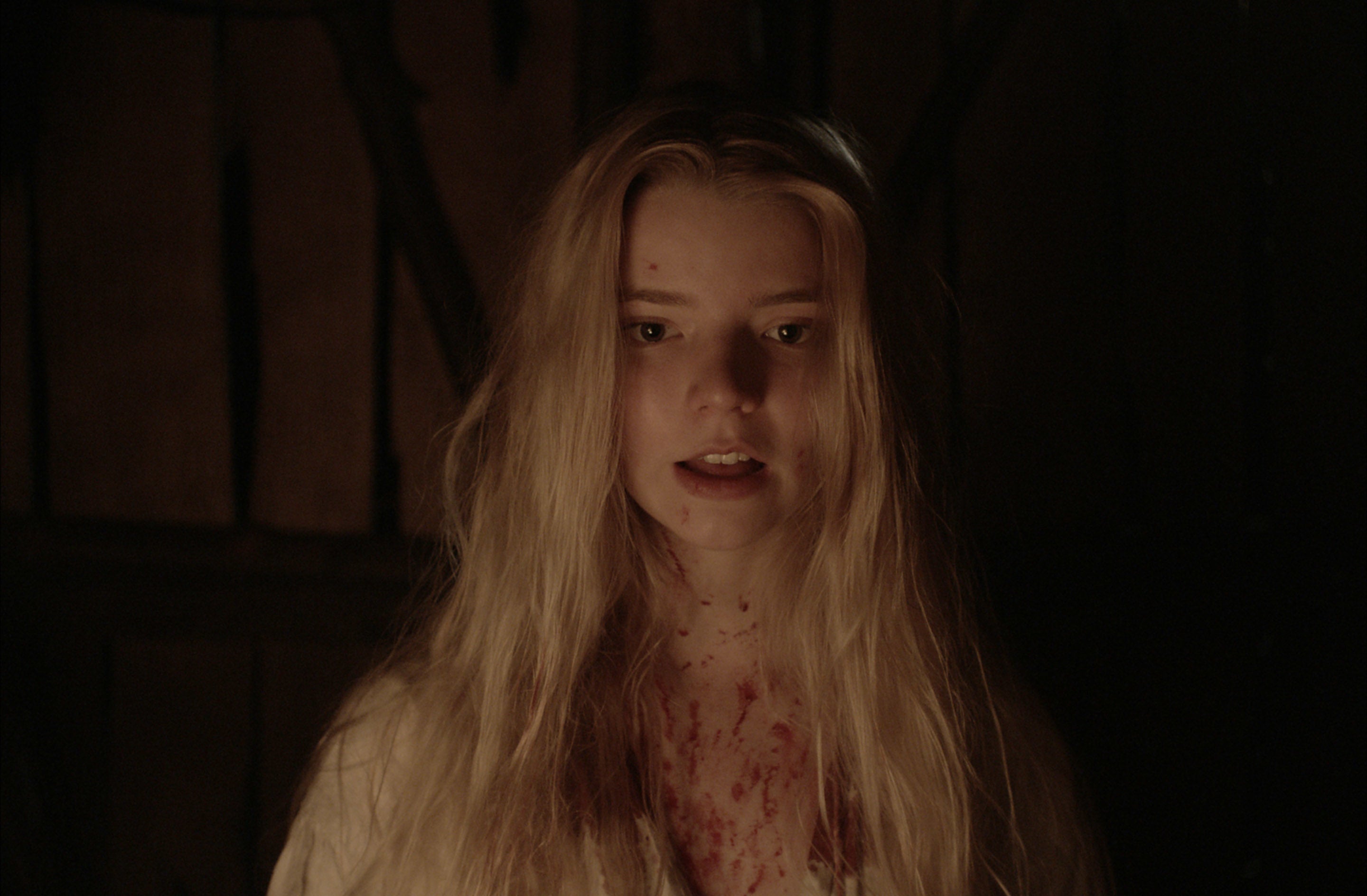 Anya Taylor-Joy with blood splatters on her chest in "The Witch"