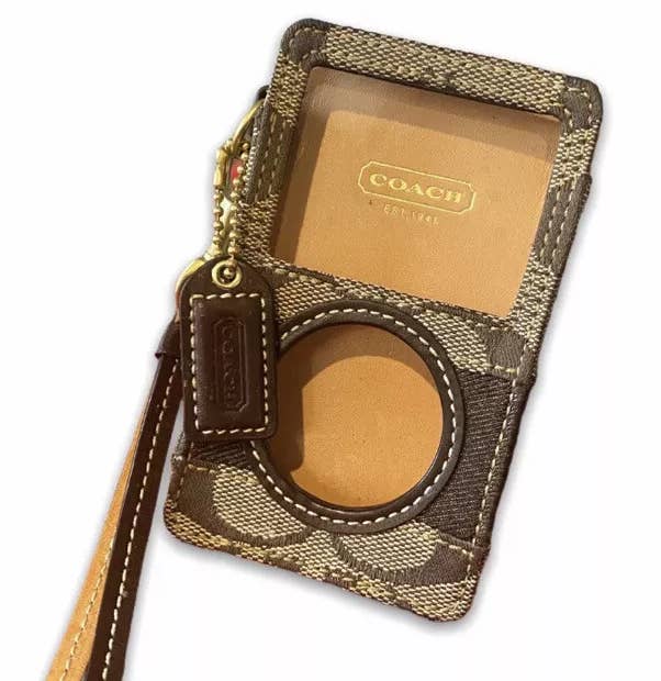 Coach-branded wallet with a keychain, featuring a transparent ID slot and a circular cutout for securing items