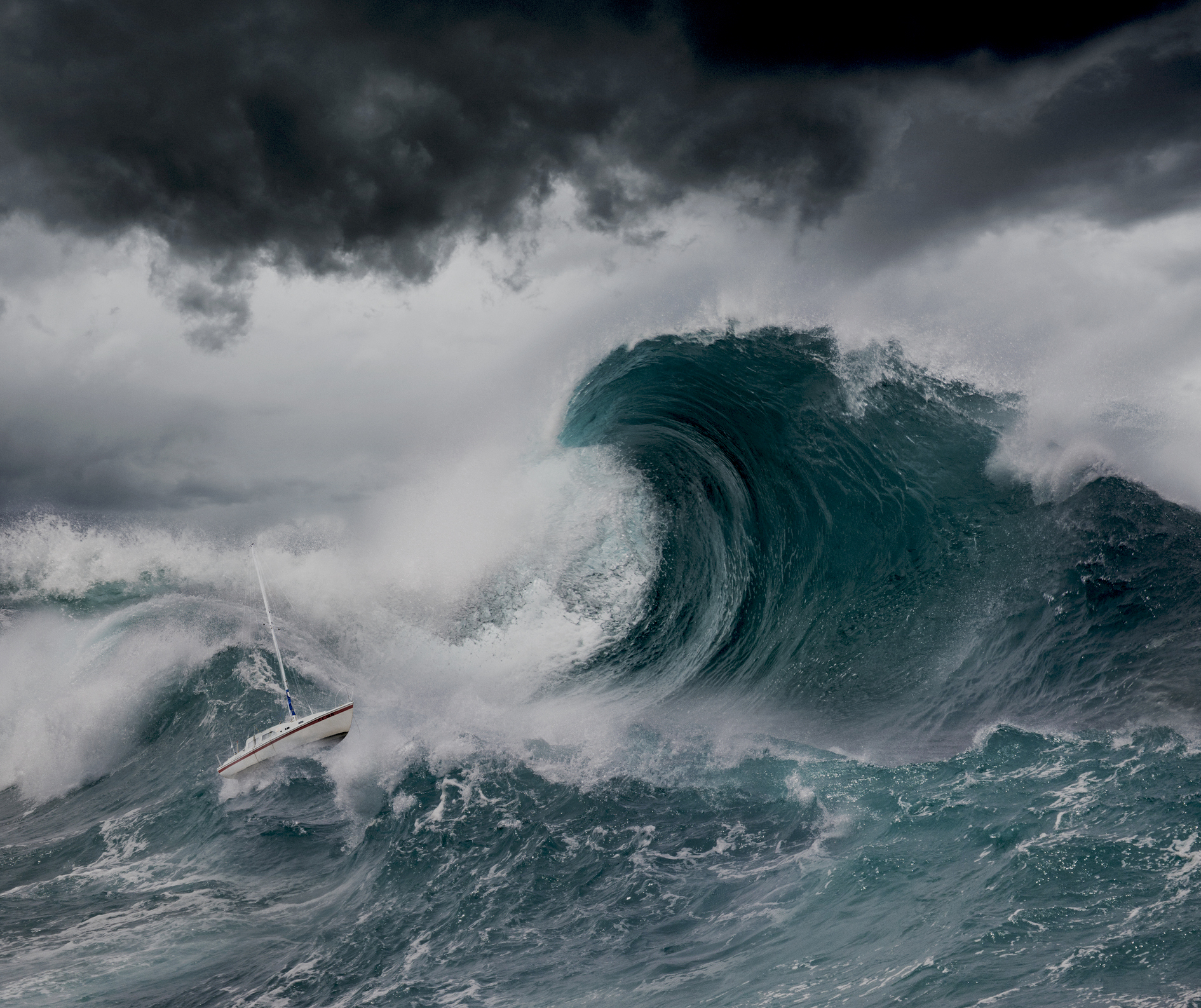A small sailboat is caught in a massive ocean wave amid a storm with dark clouds looming above
