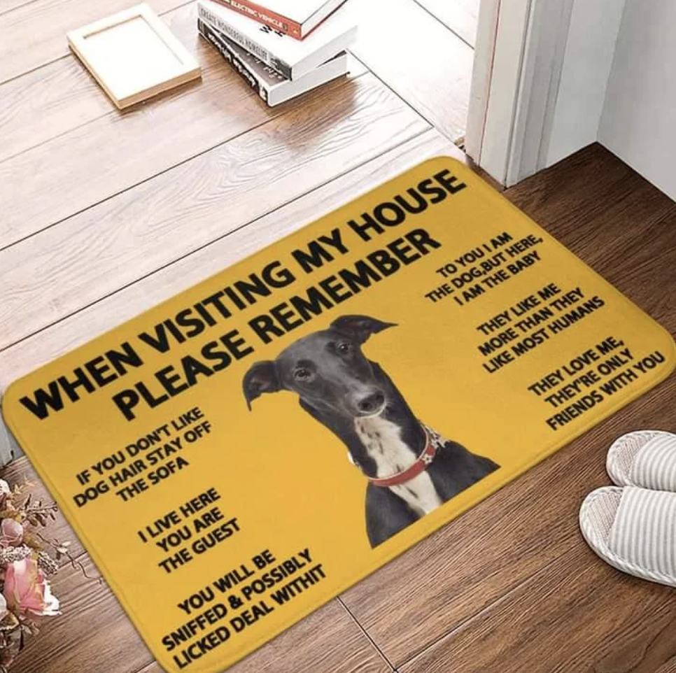 A doormat with a picture of a dog and text warning visitors about dog rules in the house, such as no hair on the sofa, being sniffed, and the dog liking some visitors more