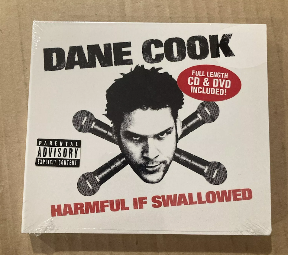 Dane Cook's album "Harmful If Swallowed" cover with Dane Cook's face and microphones. Includes a parental advisory warning and a sticker: "Full length CD &amp;amp; DVD included!"
