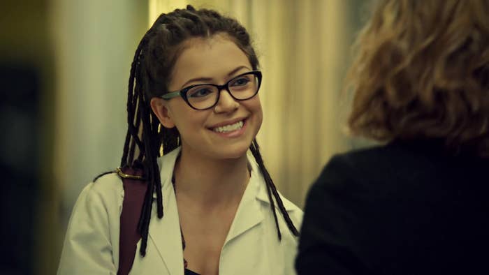 Tatiana Maslany has a joyful conversation with an unidentified person, wearing glasses and a white lab coat