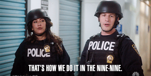 Stephanie Beatriz and Joe Lo Truglio in police gear with text overlay: &quot;That's how we do it in the Nine-Nine.&quot; #Brooklyn99 NBC