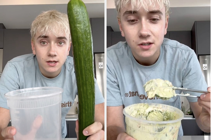 男性が台所のカウンターに立ち、大きなキュウリと透明な容器を持っている。