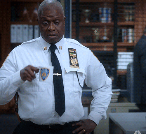 Andre Braugher, as Captain Raymond Holt in Brooklyn Nine-Nine, sternly looks at a mug with a police crest while in an office. Text reads &quot;#Brooklyn99 NBC&quot;