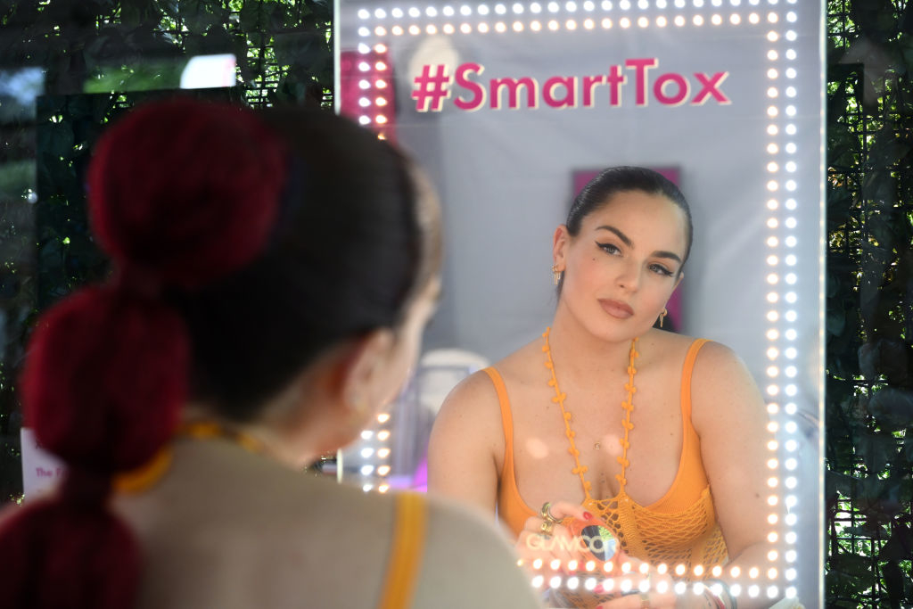 JoJo looking into a mirror with the hashtag #SmartTox displayed at the top