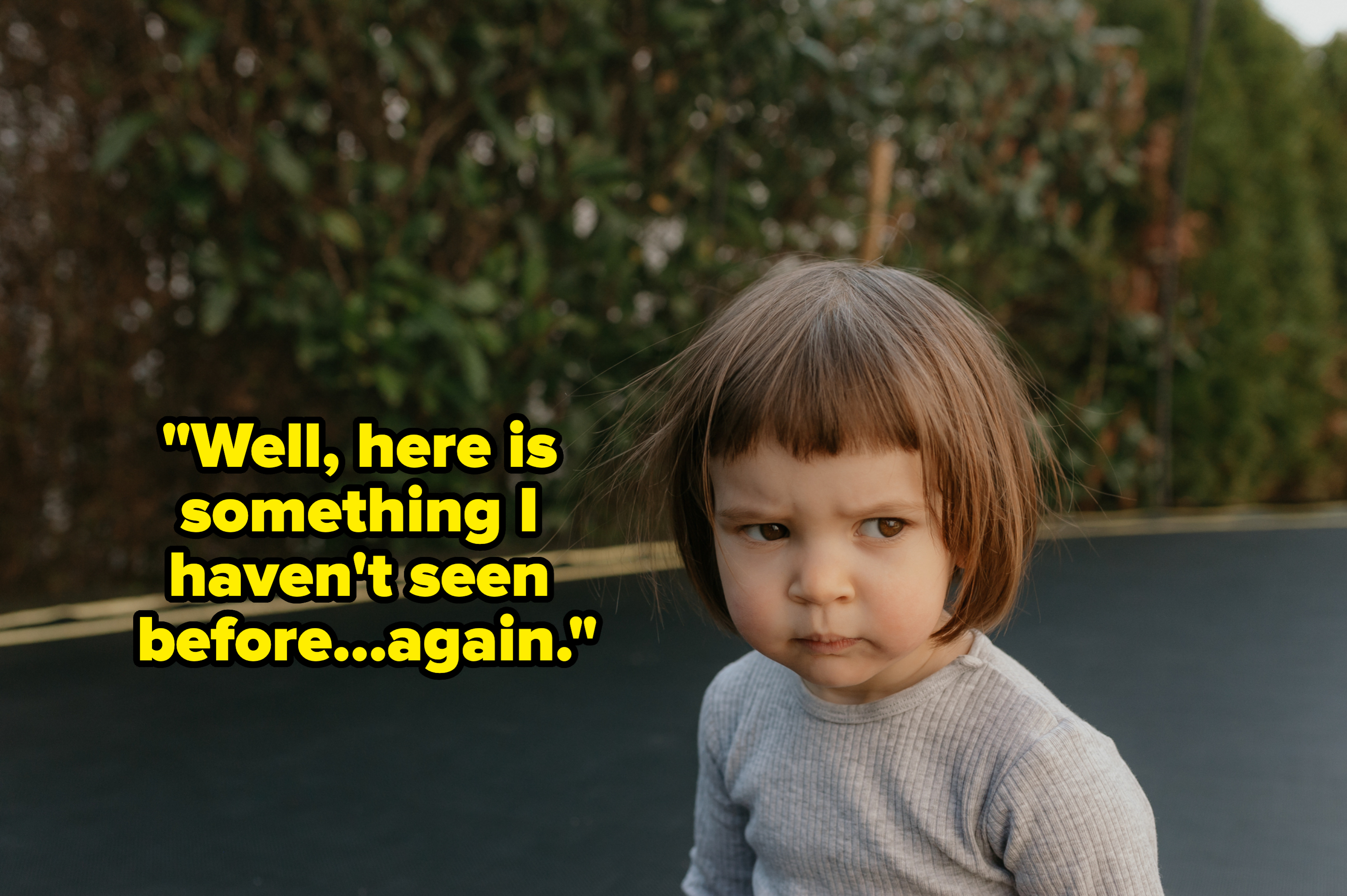 A young child on a trampoline, looking serious with a slightly furrowed brow